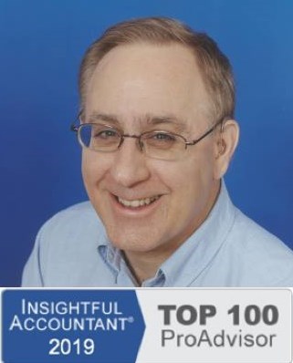 Photograph of Keith Gormezano, famous Advanced Certified QuickBooks ProAdvisor and QuickBooks Consultant, Trainer, Tutor, Instructor, Coach, or Teacher for new businesses and start ups in Seattle, Washington State who offers personalized, in person, one-on-one help, support, classes and training or clean up or set up assistance at your place, his, a quiet coffee shop, library, or other place with secure WiFi, or online using the phone and/or Instant Messenging (IM) wearing a pale blue button down business formal Nordstrom's shirt made of soft 100% cotton, short slightly receding light brown hair with a touch of gray showing his wisdom, blue eyes, trendy horizontal glasses with TransitionsB. photochromic lenses and flexible titaniam frames from Greenwood Optical, two behind the ear (BTE) CantuB 780D hearing aids from The Hear Center since replaced by two Phonak Savia Arts with Bluetooth receivers from the Veteran's Administration for free for his service so he can use them with his new cell phone with the company's SmartLink BlueTooth bridge and directional microphone device in noisy settings, and his always present smile and patience.